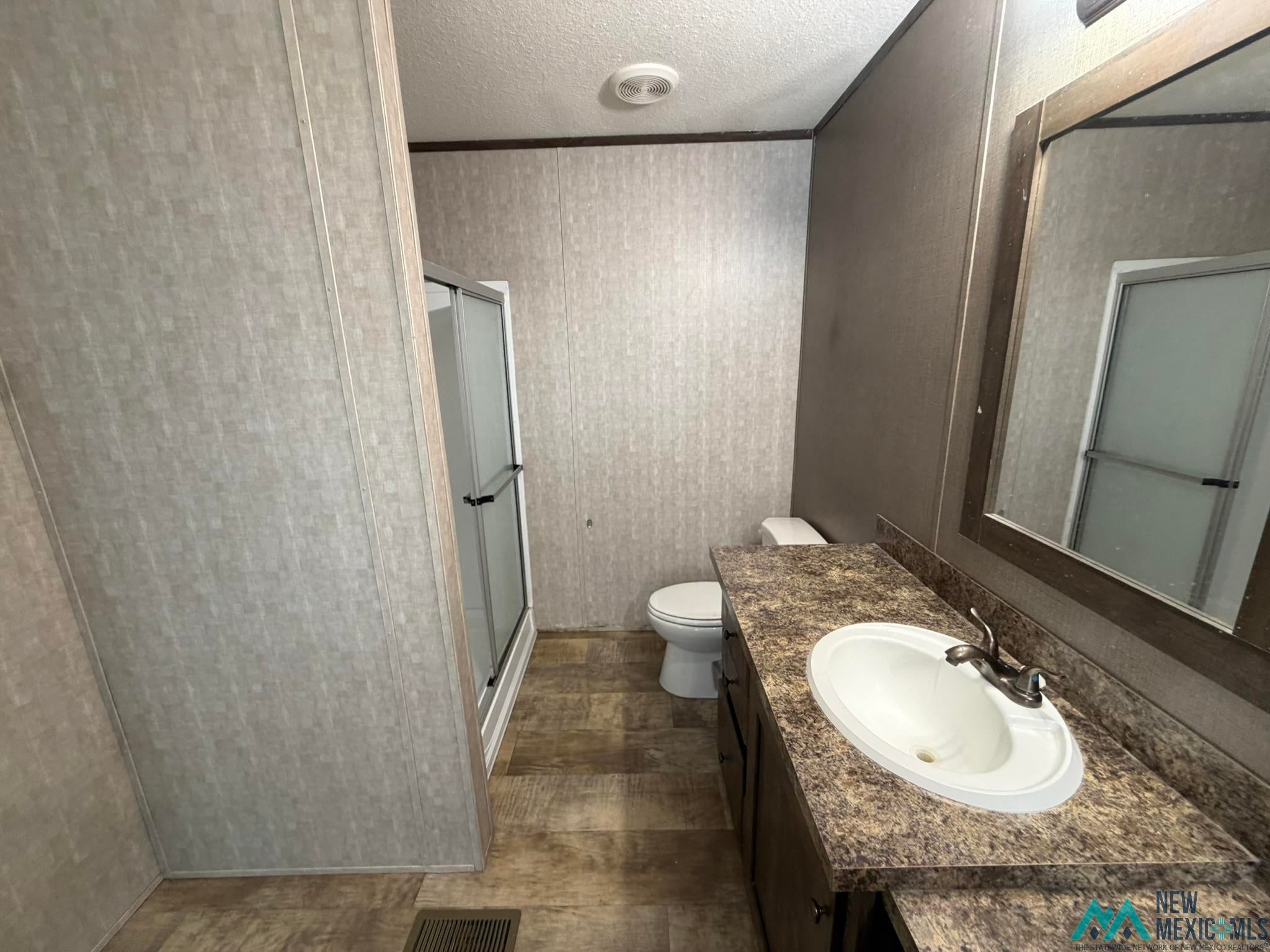 801 Riata Road Carlsbad, NM 88220 - Photo 34 of 39 Bathroom featuring a built-in vanity with an integrated sink and a framed mirror