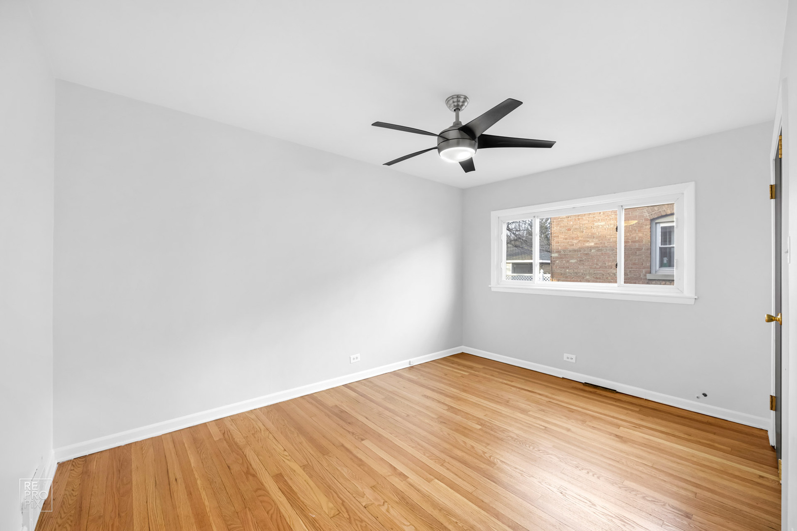 12552 South Harvard Avenue Chicago, IL 60628 - Photo 5 of 9 a view of an empty room with wooden floor and a window
