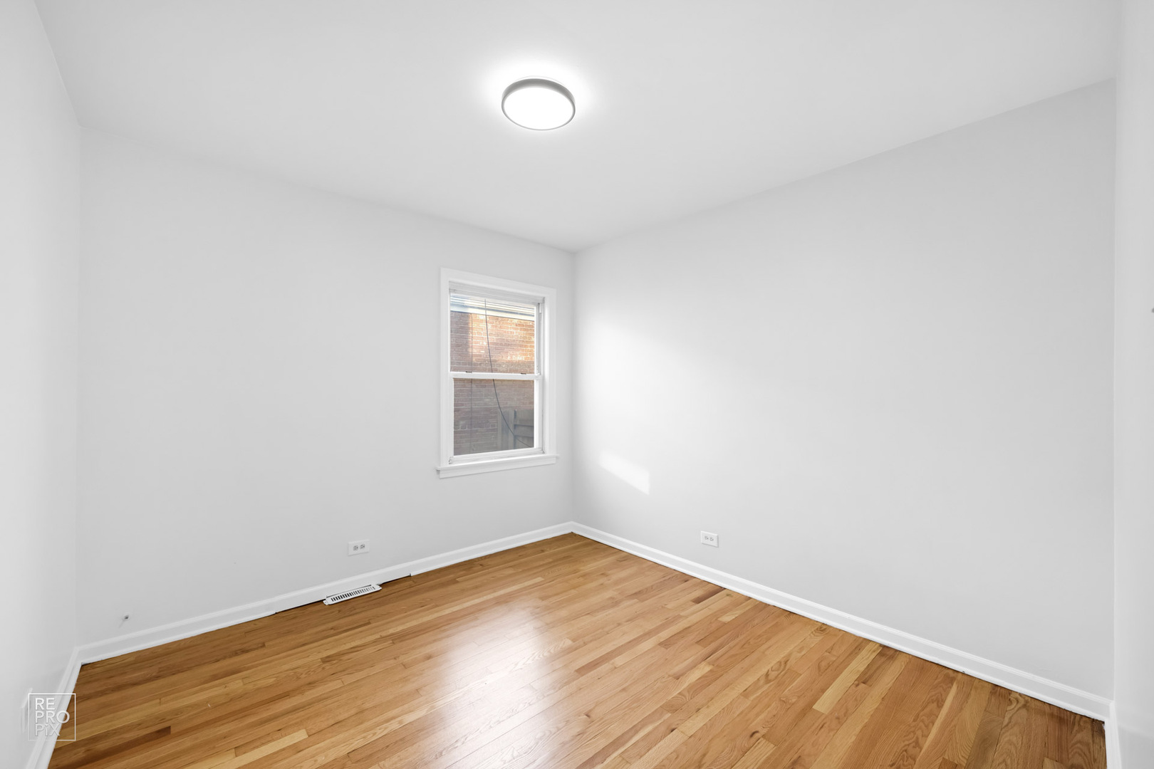 12552 South Harvard Avenue Chicago, IL 60628 - Photo 6 of 9 an empty room with wooden floor and windows