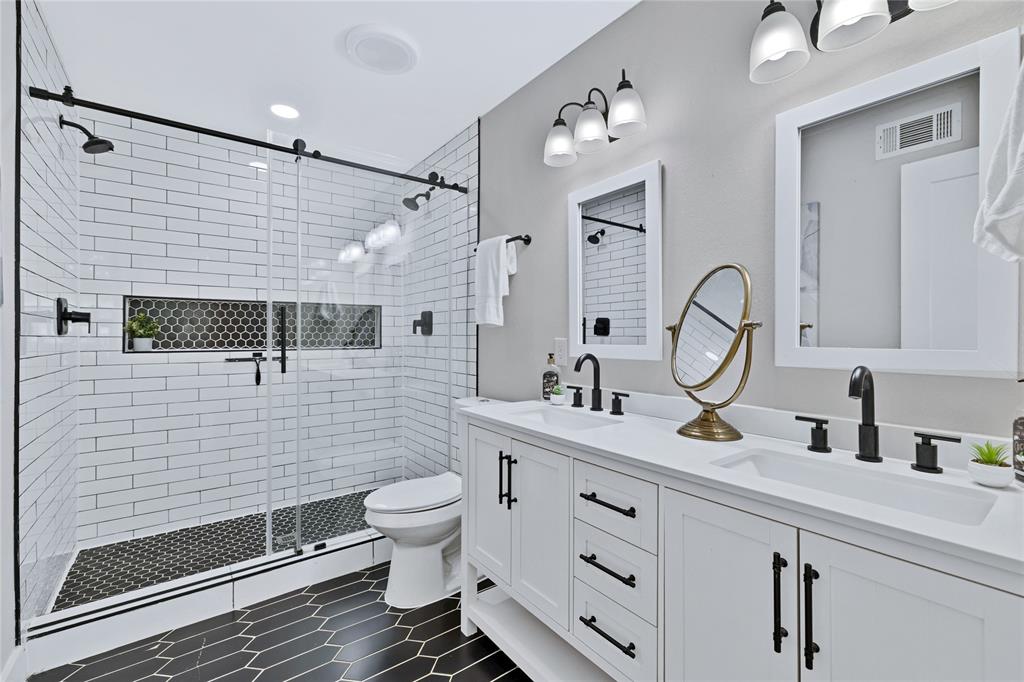 8635 Strathmore Drive Dallas, TX 75238 - Photo 18 of 35 a bathroom with a sink mirror and toilet