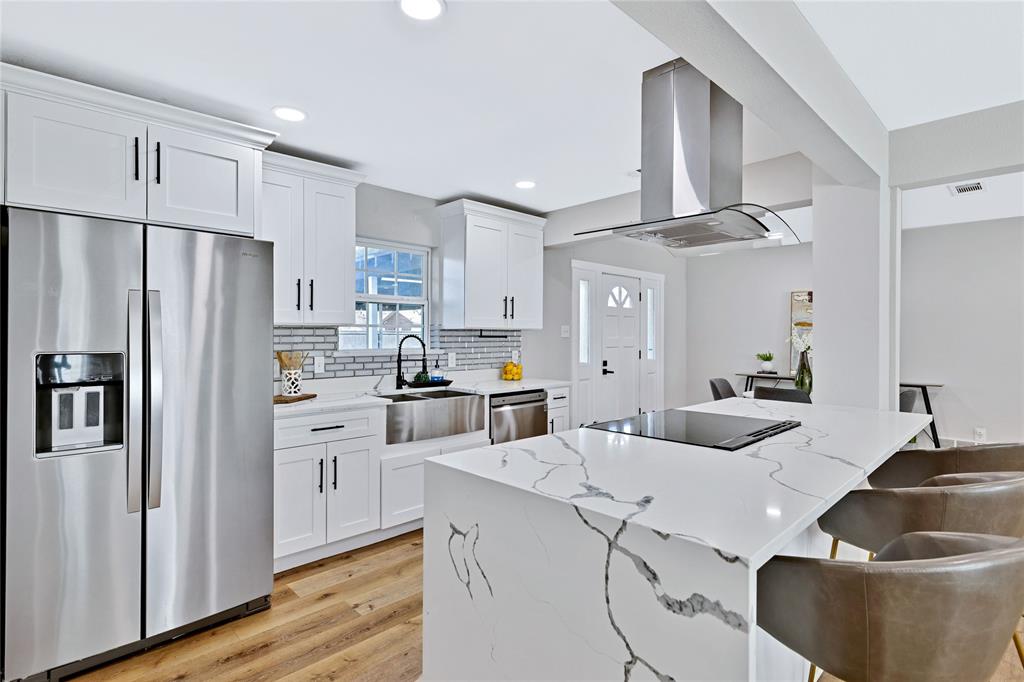 8635 Strathmore Drive Dallas, TX 75238 - Photo 3 of 35 a kitchen with white cabinets and stainless steel appliances