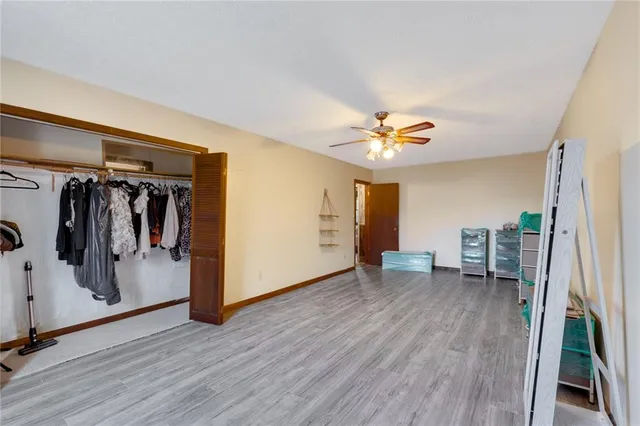 a view of a livingroom with wooden floor and a ceiling fan
