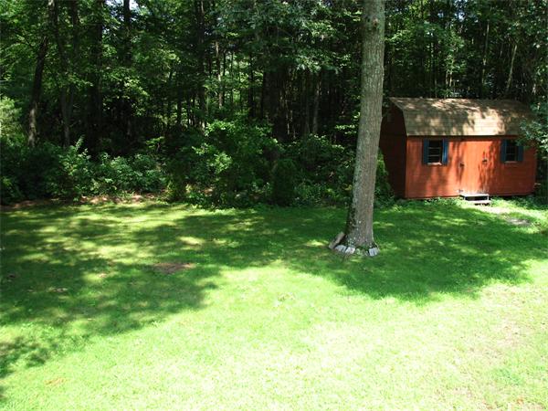 64 Baker Road Salisbury, MA 01952 - Photo 10 of 29 a backyard of a house with plants and large trees