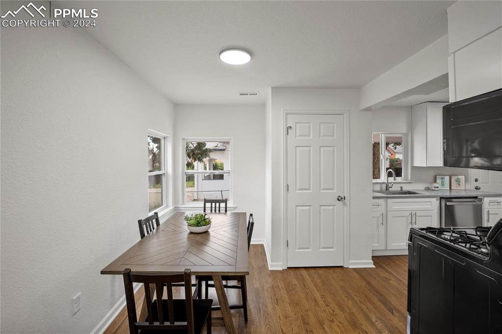 2615 East Boulder Street Colorado Springs, CO 80909 - Photo 12 of 50 a kitchen with stainless steel appliances granite countertop a stove top oven a sink a dining table and chairs