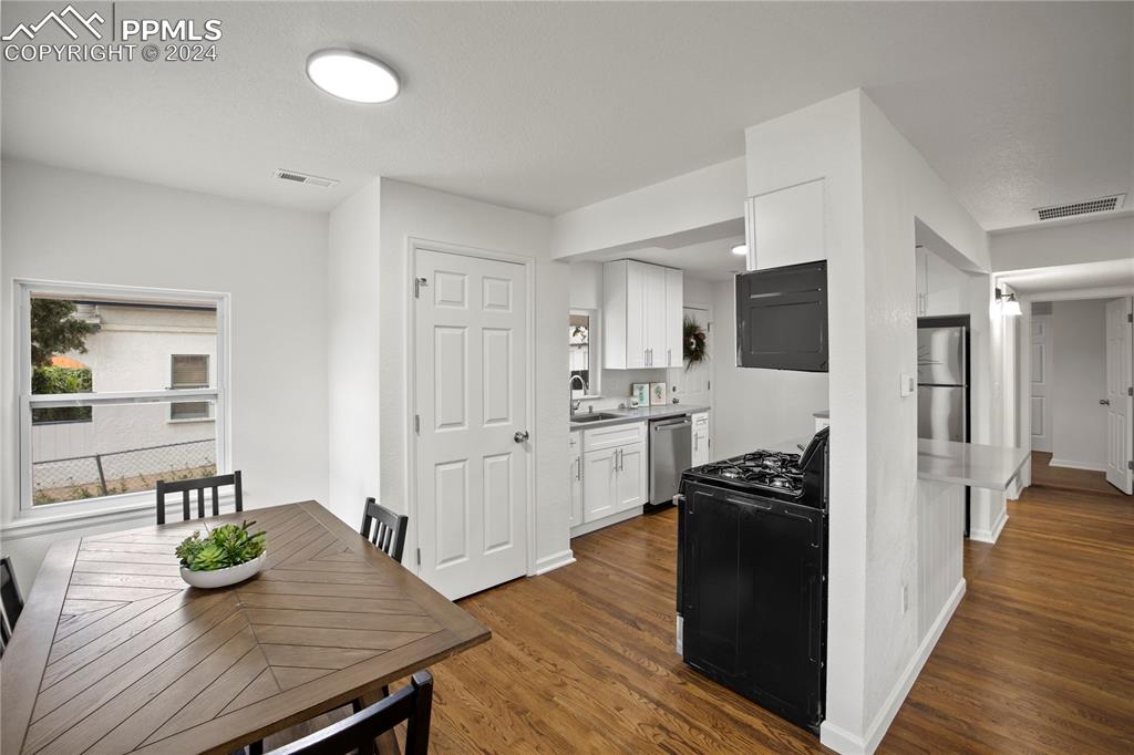 2615 East Boulder Street Colorado Springs, CO 80909 - Photo 13 of 50 a kitchen with sink cabinets and wooden floor