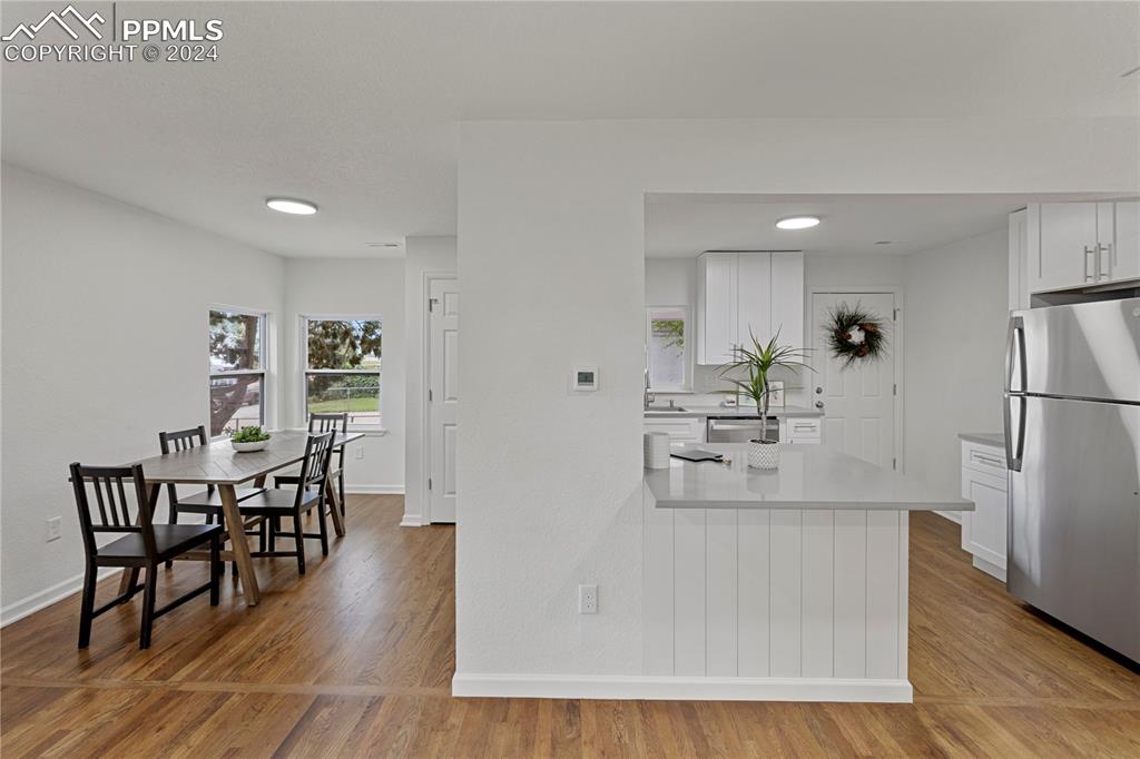 2615 East Boulder Street Colorado Springs, CO 80909 - Photo 14 of 50 a kitchen with stainless steel appliances a dining table chairs and wooden floor