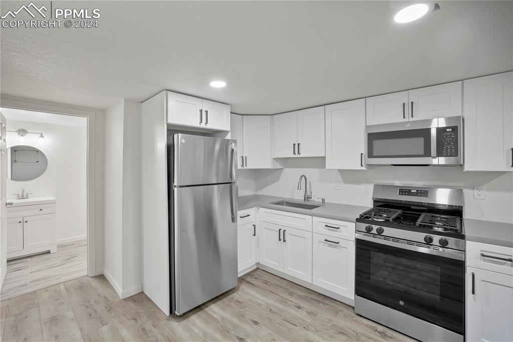 2615 East Boulder Street Colorado Springs, CO 80909 - Photo 22 of 50 a kitchen with stainless steel appliances a refrigerator stove and microwave