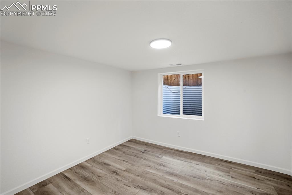 2615 East Boulder Street Colorado Springs, CO 80909 - Photo 26 of 50 an empty room with wooden floor and window