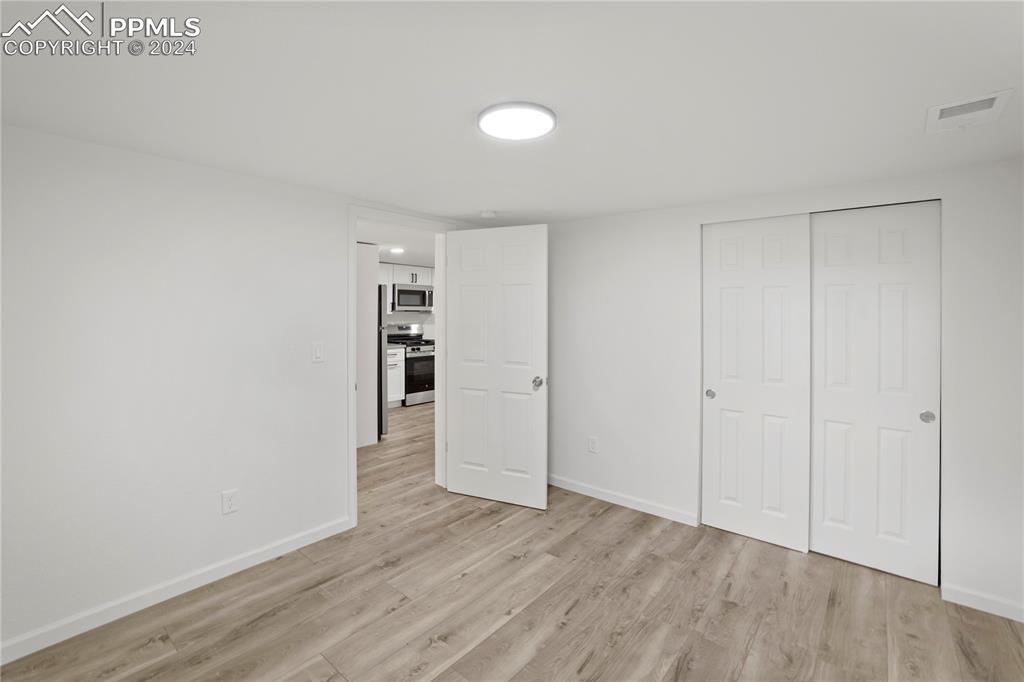 2615 East Boulder Street Colorado Springs, CO 80909 - Photo 29 of 50 a view of an empty room with wooden floor and closet