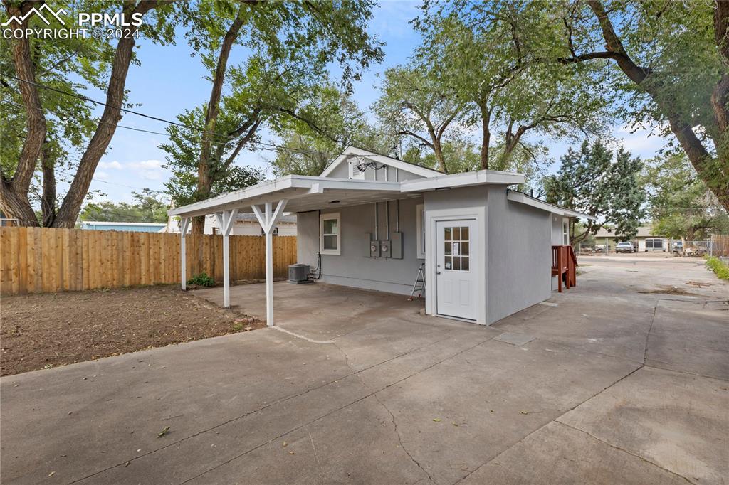 2615 East Boulder Street Colorado Springs, CO 80909 - Photo 41 of 50 a view of a white house with a large tree and wooden fence