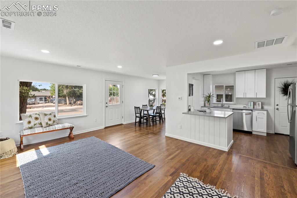 2615 East Boulder Street Colorado Springs, CO 80909 - Photo 5 of 50 a living room with stainless steel appliances kitchen island granite countertop furniture wooden floor and a rug