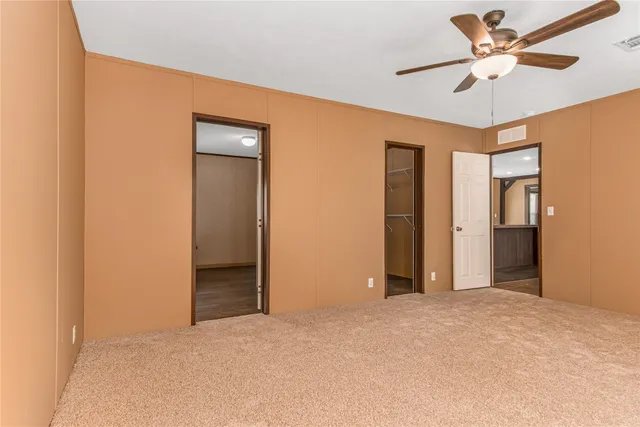 a view of a big room with closet and a ceiling fan