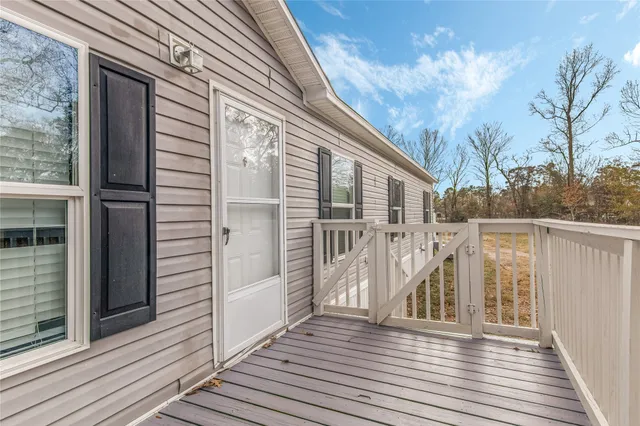 a view of a balcony with wooden floor and fence