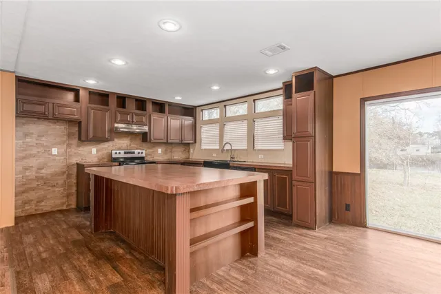 a kitchen with stainless steel appliances granite countertop a sink stove and refrigerator