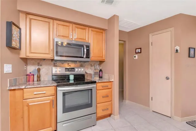 a kitchen with stainless steel appliances granite countertop stove top oven a sink dishwasher and a microwave oven on the blue kitchen countertops
