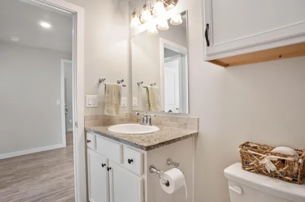 a bathroom with a granite countertop sink and a mirror