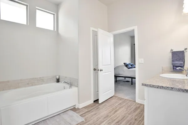 a bathroom with a granite countertop double vanity sink a mirror and a shower