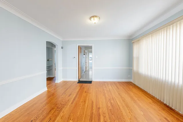 a view of a big room with wooden floor and windows
