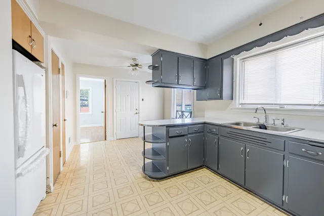 a kitchen with stainless steel appliances granite countertop a sink and a refrigerator