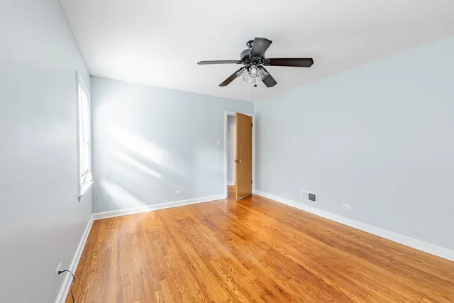 a view of room with a ceiling fan and wooden floor