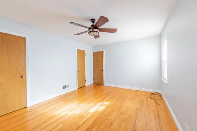 a view of a big room with wooden floor and windows in a room