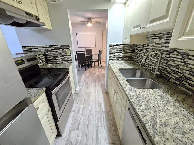a kitchen with stainless steel appliances granite countertop a sink and a stove