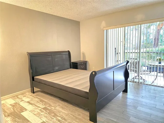 a large bed sitting in a bedroom next to a window with dresser