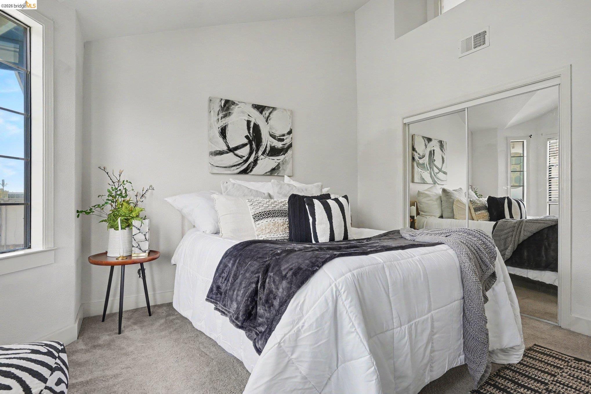 1433 Myrtle Street Oakland, CA 94607 - Photo 15 of 25 Bedroom featuring light-toned carpeting, a tall window with black framing, and white walls