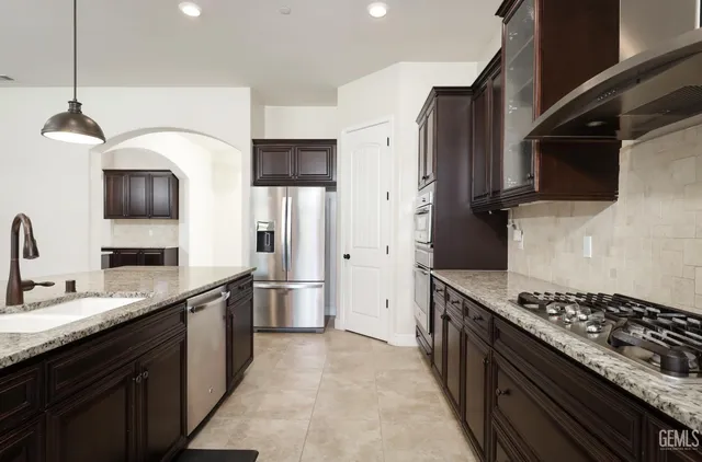 a kitchen with stainless steel appliances kitchen island granite countertop a kitchen island a table and chairs