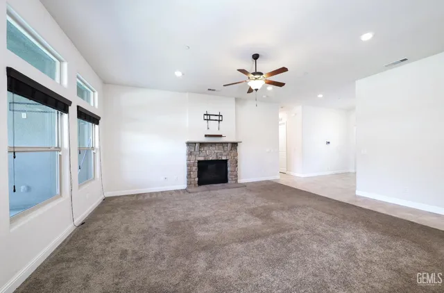 a large white kitchen with stainless steel appliances kitchen island a large counter top and a stove