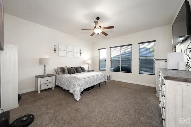 a large bathroom with a granite countertop double vanity large mirror bathtub shower and toilet