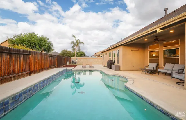 a view of house with swimming pool and furniture