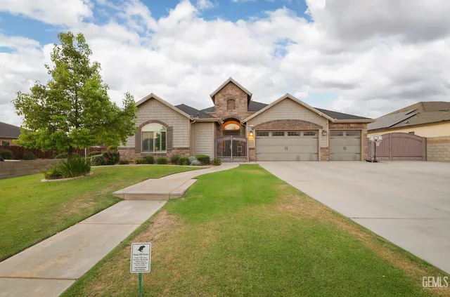 a front view of a house with a garden and yard