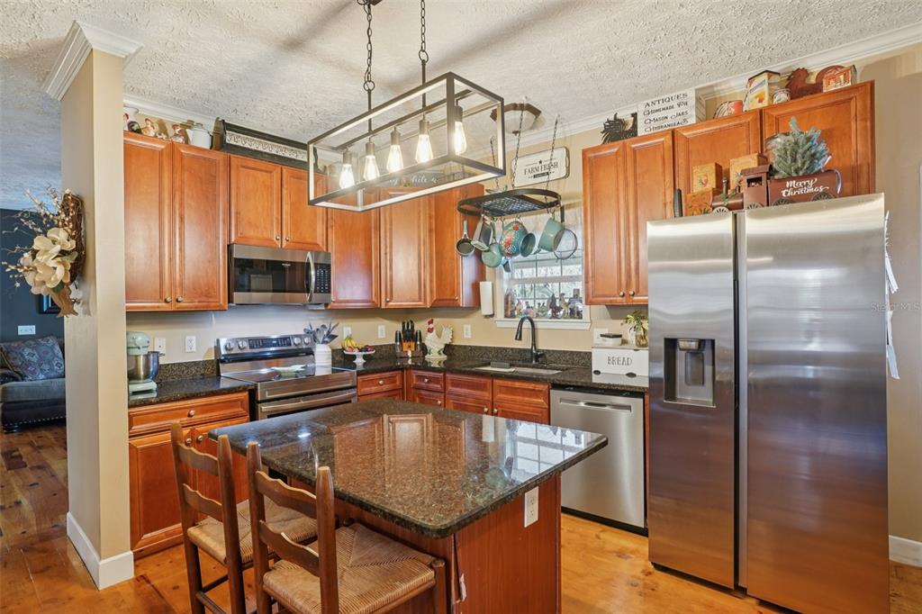 7459 Southwest 5th Avenue Ocala, FL 34476 - Photo 17 of 55 a kitchen with stainless steel appliances granite countertop a refrigerator a sink a stove a table and chairs