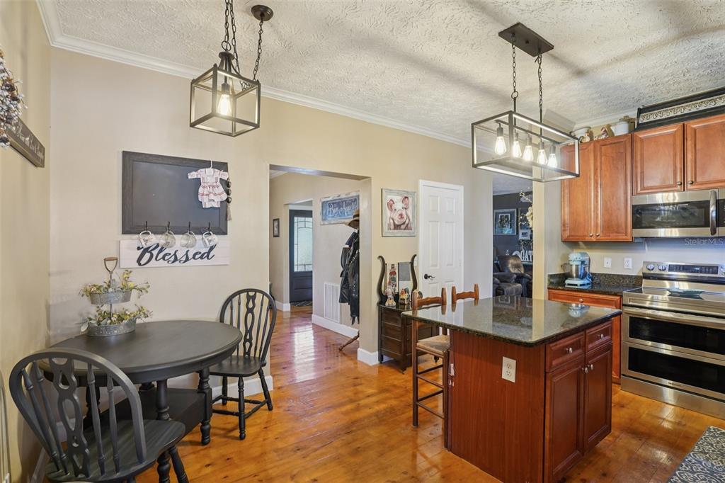 7459 Southwest 5th Avenue Ocala, FL 34476 - Photo 18 of 55 a kitchen with stainless steel appliances granite countertop a stove a refrigerator a kitchen island a dining table and chairs with wooden floor