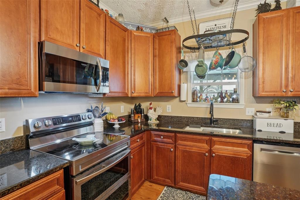 7459 Southwest 5th Avenue Ocala, FL 34476 - Photo 19 of 55 a kitchen with granite countertop a sink a stove and cabinets