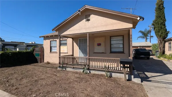 a view of a house with a patio and a yard