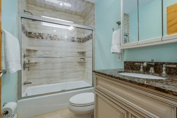 a bathroom with a granite countertop toilet sink and shower