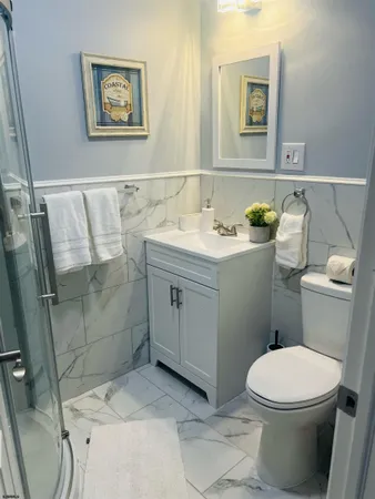 a bathroom with a granite countertop toilet a sink and mirror