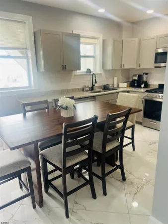 a kitchen with kitchen island a dining table chairs and a sink