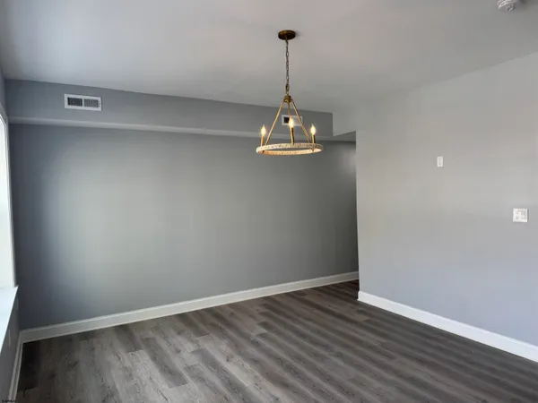 a view of a room with wooden floor and chandelier