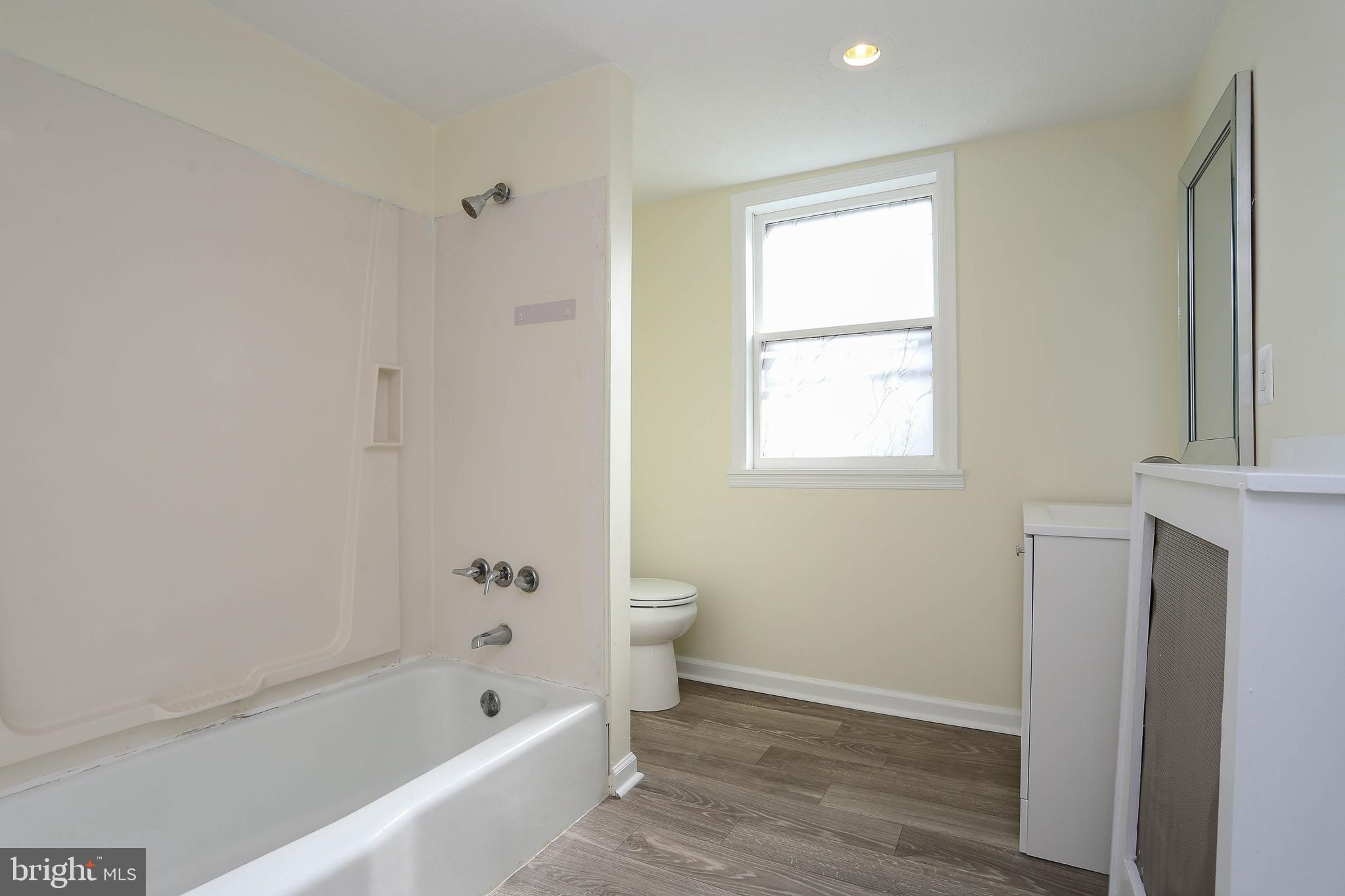 216 Clyde Avenue Halethorpe, MD 21227 - Photo 14 of 49 a bathroom with a bathtub toilet and window