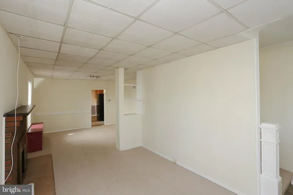 a view of empty room with a fireplace and window