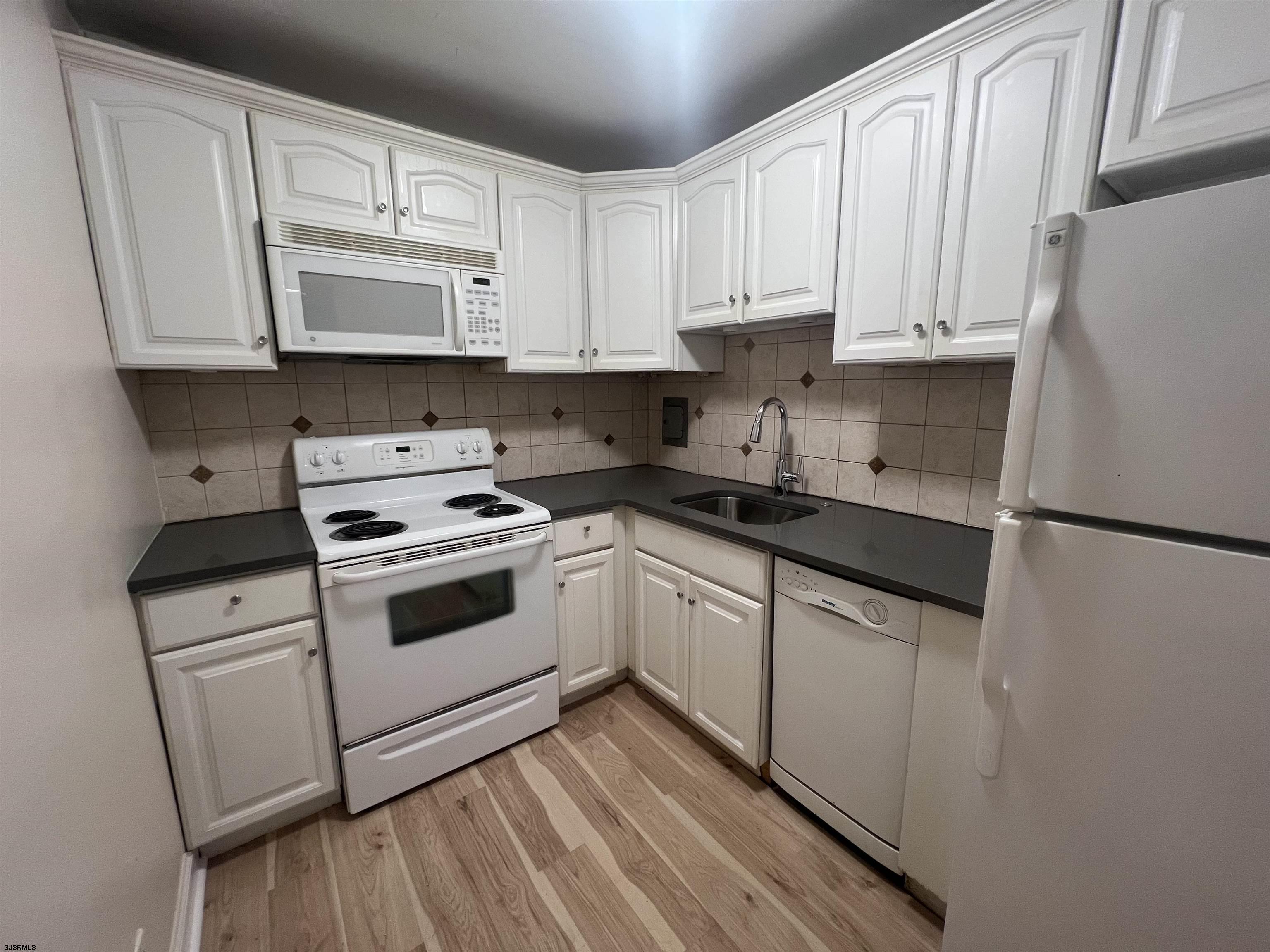 101 South Raleigh Avenue, Unit 618 Atlantic City, NJ 08401 - Photo 3 of 26 a kitchen with granite countertop white cabinets and white appliances