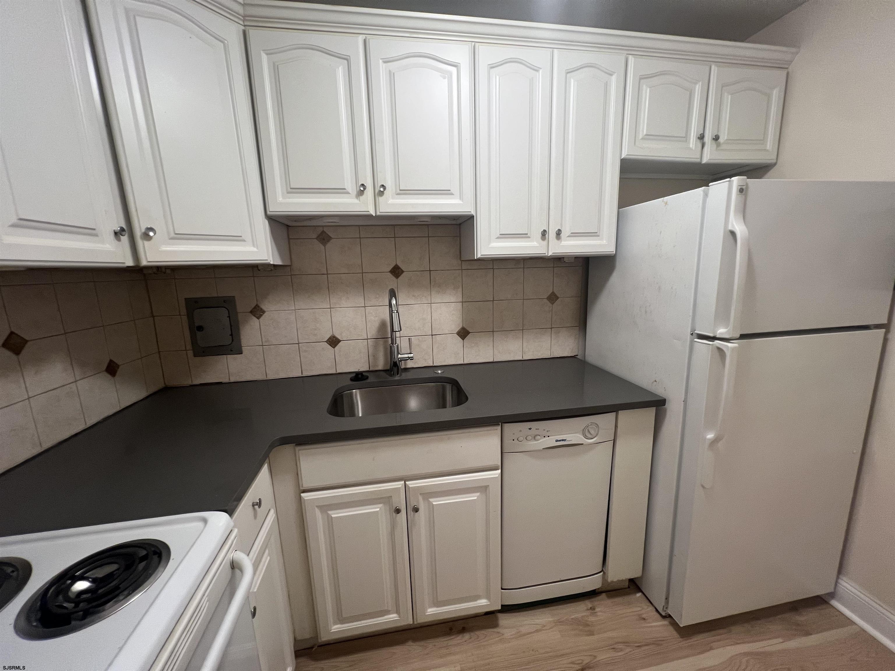 101 South Raleigh Avenue, Unit 618 Atlantic City, NJ 08401 - Photo 4 of 26 a kitchen with stainless steel appliances granite countertop a refrigerator sink and white cabinets