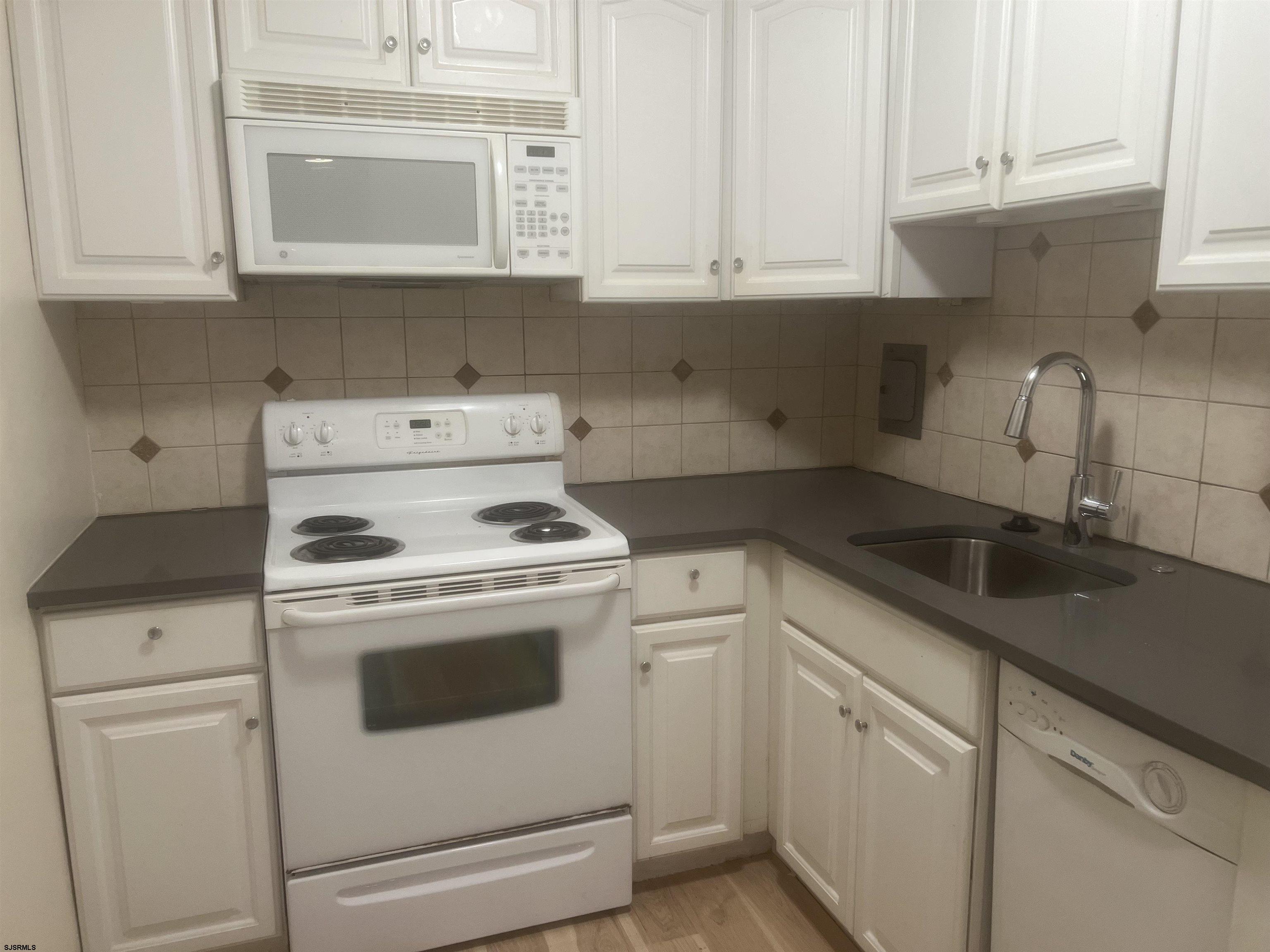 101 South Raleigh Avenue, Unit 618 Atlantic City, NJ 08401 - Photo 5 of 26 a kitchen with granite countertop white cabinets and white appliances