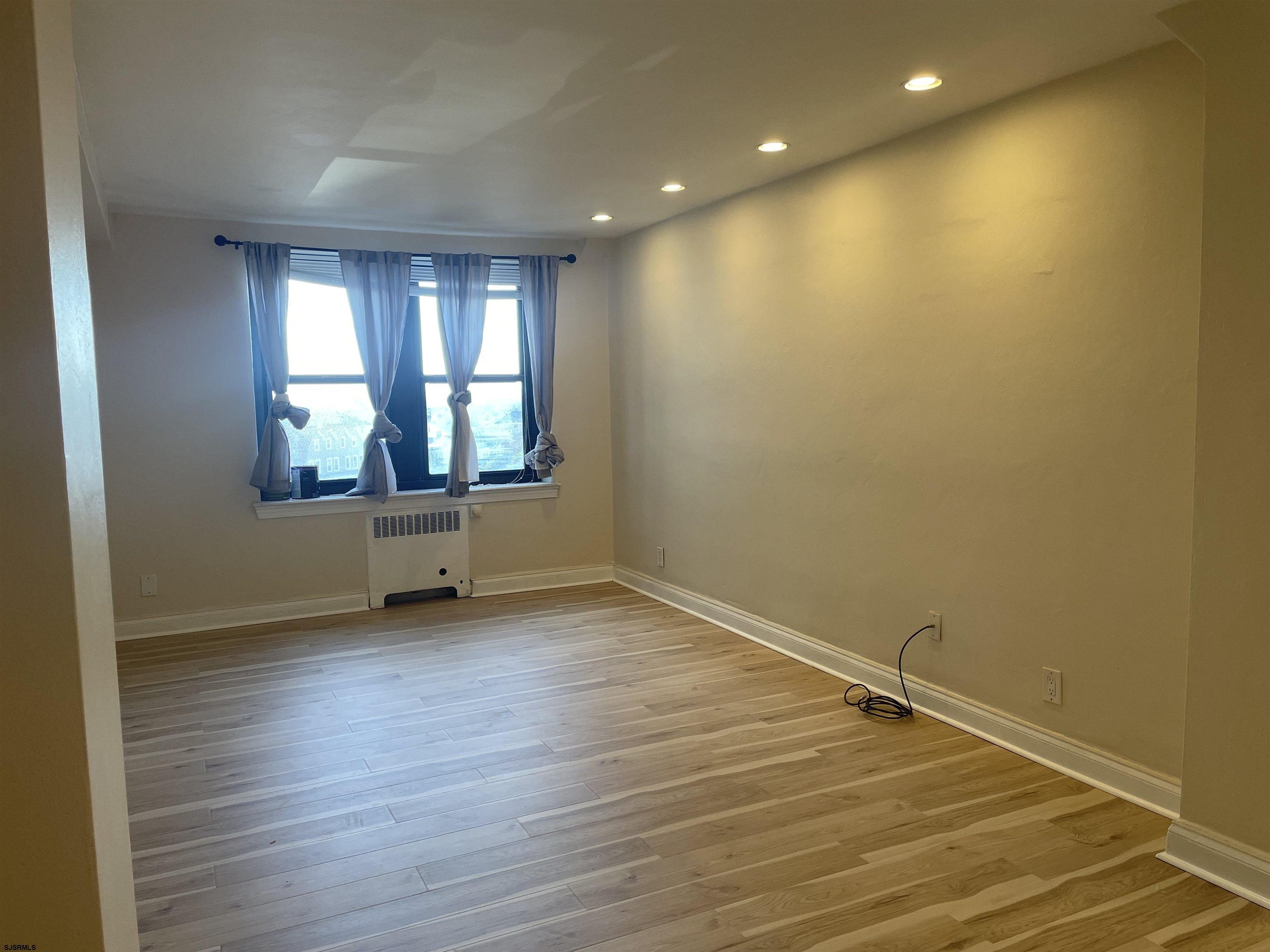 101 South Raleigh Avenue, Unit 618 Atlantic City, NJ 08401 - Photo 8 of 26 an empty room with wooden floor and windows