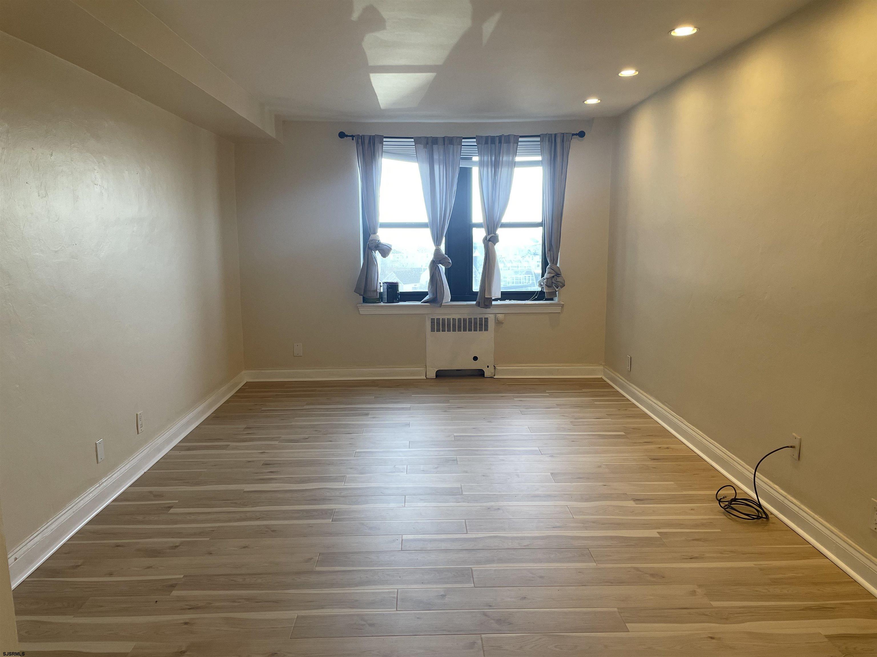101 South Raleigh Avenue, Unit 618 Atlantic City, NJ 08401 - Photo 9 of 26 an empty room with wooden floor and windows