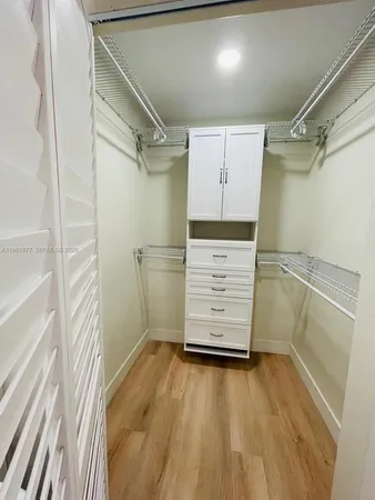 a view of walk in closet with clothes