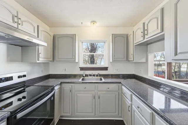 a kitchen with stainless steel appliances a sink stove and cabinets